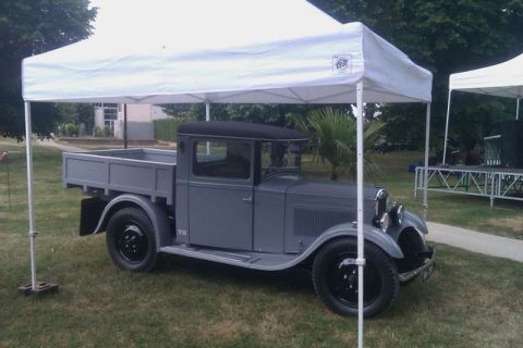 1991 Ford LTD Crown Victoria - A vintage gray pickup truck is displayed outdoors under a white canopy.