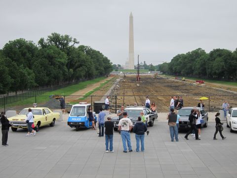 1991 Ford LTD Crown Victoria - small fleet of vintage police vehicles and a gathered crowd on a plaza facing the distant Washington Monument.