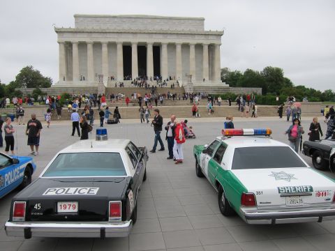 1991 Ford LTD Crown Victoria - black-and-white police car and a green-and-white Sheriff cruiser parked on the plaza before the Lincoln Memorial.