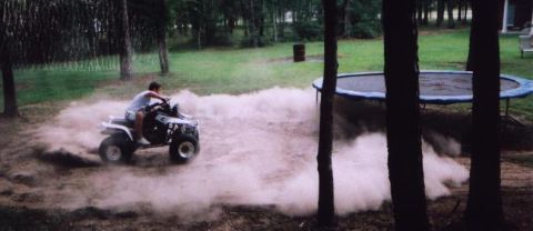 1989 Ford Bronco - An ATV spins around, creating a large dust cloud in a backyard setting.