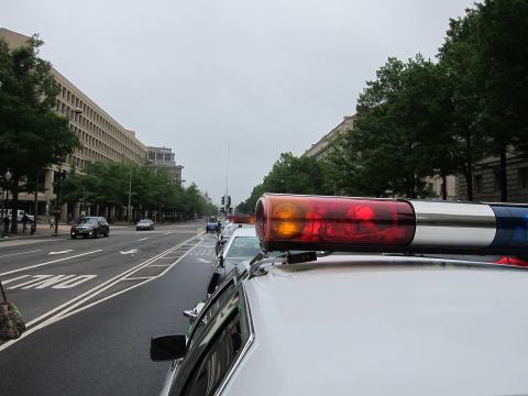 1991 Ford LTD Crown Victoria - Close-up of a red-and-amber roof light bar on a police cruiser parked along a tree-lined Washington city street.