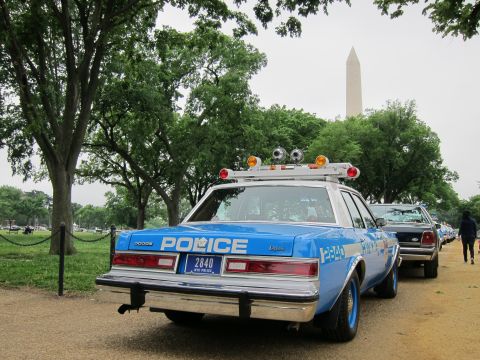 1991 Ford LTD Crown Victoria - blue NYPD police sedan numbered 2840 with a light bar, seen from the rear with the Washington Monument in the background.