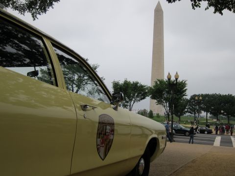 1991 Ford LTD Crown Victoria - Close-up of a yellow police car's door shield with the Washington Monument rising in the cloudy background.