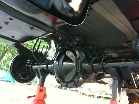1996 Ford Bronco - The rear axle assembly of a vehicle is shown, supported by red jack stands.