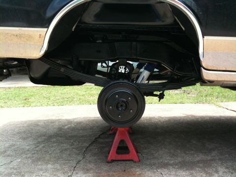 1996 Ford Bronco - The rear axle and suspension components of a 1996 Ford Bronco are visible while supported by jack stands.