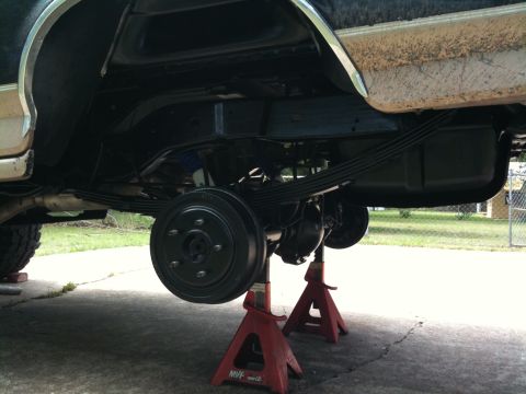 1996 Ford Bronco - Undercarriage view of a vehicle being serviced, with the rear suspension components clearly visible.