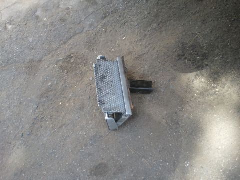 1978 Ford Bronco - A single metal step bumper part is shown lying on a concrete surface.