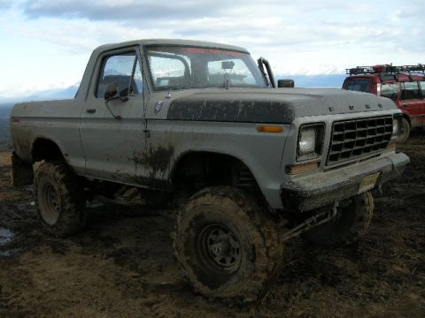 1990 Chevrolet Suburban - This lifted 1978 Ford Bronco is covered in mud after off-roading, with another vehicle visible behind it.
