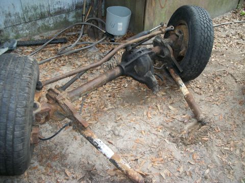 1994 Ford Explorer - A vehicle's front axle assembly, complete with tires and suspension parts, rests on the ground.
