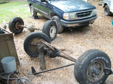 1994 Ford Explorer - A blue Ford Explorer is shown with its rear axle assembly disassembled and placed in front of the vehicle.