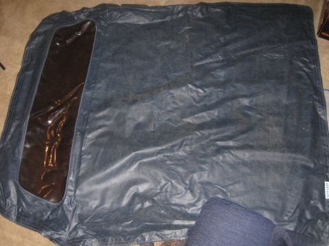 1990 Ford Bronco - Soft top for a convertible, possibly for a Ford Bronco, laid out on the floor.