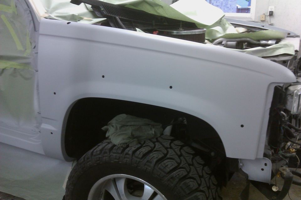 White SUV fender and tire, undergoing repair