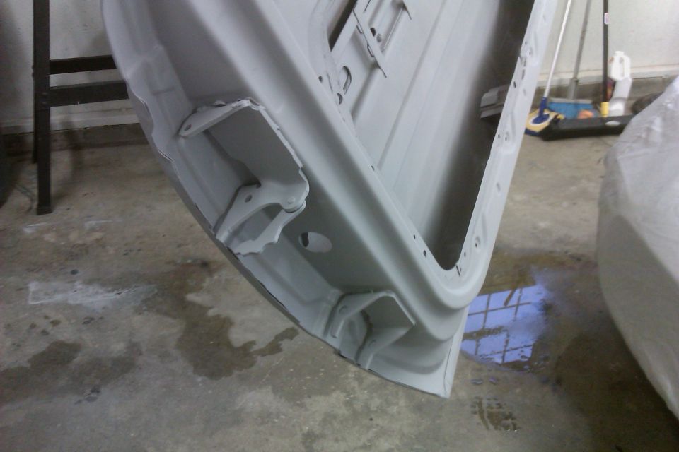 Gray car door interior, showing mounting points and primer