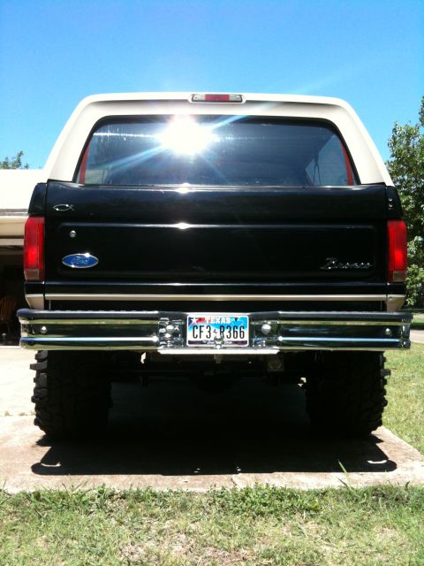 1996 Ford Bronco - The rear of a black and tan 1996 Ford Bronco is shown, a chrome bumper and a license plate.