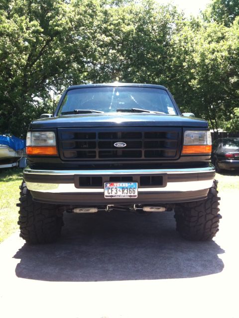 1996 Ford Bronco - This lifted black Ford Bronco is viewed from the front, its modified suspension and off-road tires.