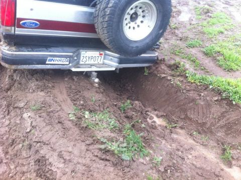1990 Ford Bronco - This Ford Bronco is stuck in the mud, with its rear bumper and spare tire visible.