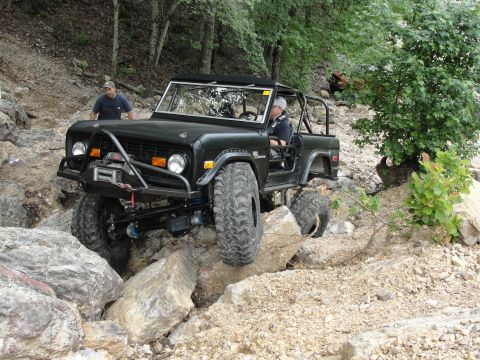 1967 Ford Mustang - Ford Bronco tackling a challenging rocky obstacle during an off-road excursion.