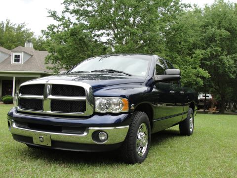 1967 Ford Mustang - A blue 2003 Dodge Ram pickup truck is parked on a grassy lawn in front of a house.