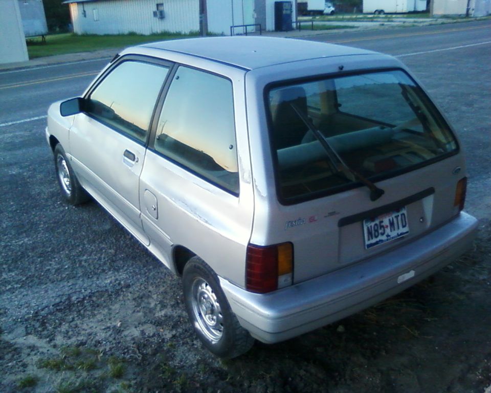 Silver 1991 Ford Festiva hatchback, rear 3/4 view. License plate N85-HTD