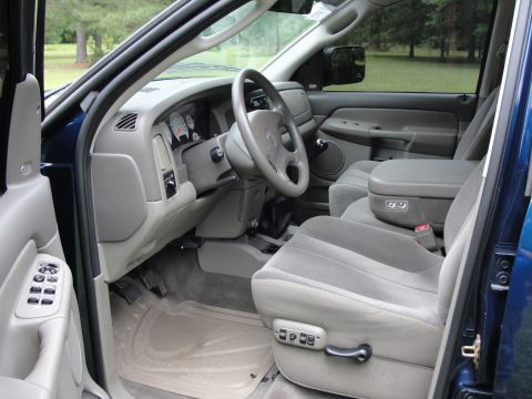 1967 Ford Mustang - The interior of a blue truck is shown, cloth seats and a center console.