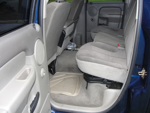 1967 Ford Mustang - The interior of a blue pickup truck is visible, with gray cloth seats and door panels.