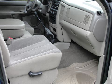 1967 Ford Mustang - The interior of a truck features gray cloth seats, a center console, and a floor-mounted shifter.