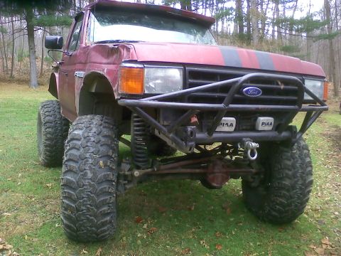 1988 Ford Bronco - This lifted 1988 Ford Bronco features aggressive off-road tires and a heavy-duty brush guard, ready for any terrain.