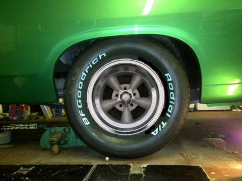 1971 Ford Ranchero - A close-up of a green vehicle's side, focusing on the wheel and tire assembly.