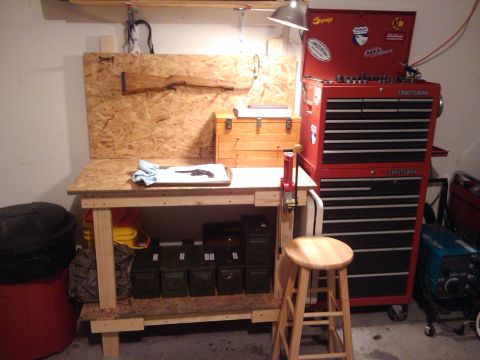 1989 Ford Bronco - A workbench is set up for firearm maintenance, complete with tools, ammunition storage, and a large red toolbox.