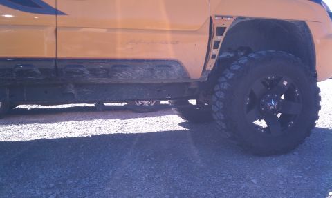 1994 Ford Bronco - Side view of a yellow SUV with aftermarket wheels and tires.