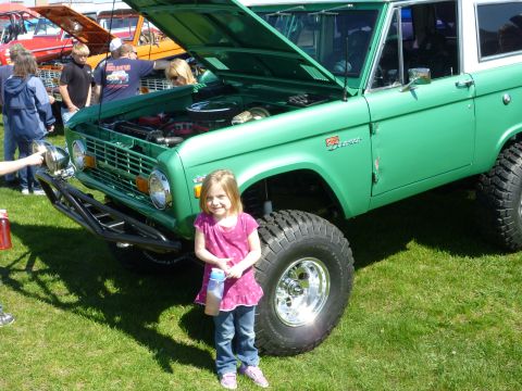 1995 Ford Bronco - A green 1978 Ford Bronco is displayed with its hood open, while a young girl poses in front of it.