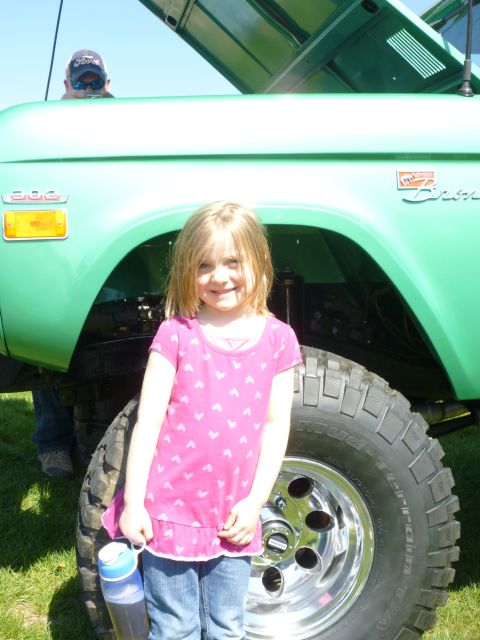 1995 Ford Bronco - A young girl poses in front of a green Ford Bronco with its hood open.