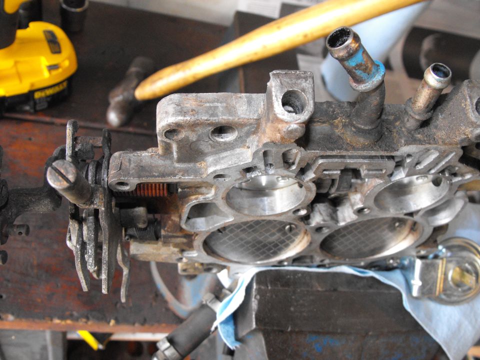 The area to the left of the unblocked idle mixture screws is cleaned off and ready to drill