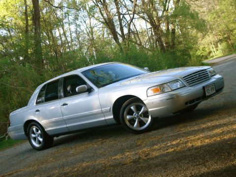 2000 Ford Crown Victoria - Silver 2000 Ford Crown Victoria with aftermarket wheels parked outdoors.
