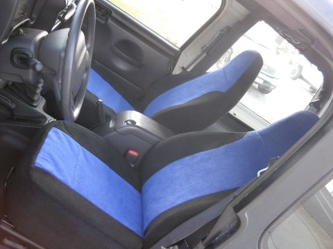 1990 Ford Probe - The interior of a Jeep Wrangler TJ features blue and black seat covers and a manual transmission shifter.