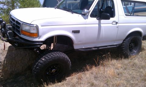 1978 Ford Bronco - This white Ford Bronco features significant off-road modifications, including a lift kit and large tires.