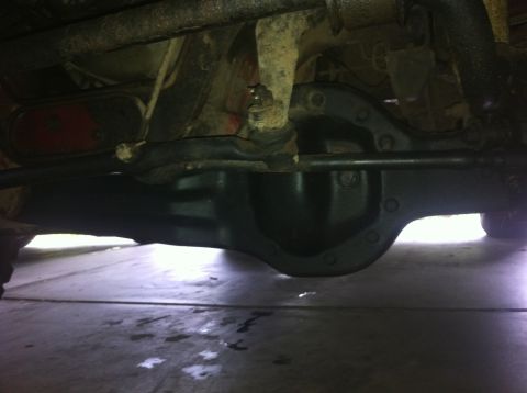 1990 Ford Bronco - Underside view of a vehicle's differential and suspension components, with a partial view of a taillight.