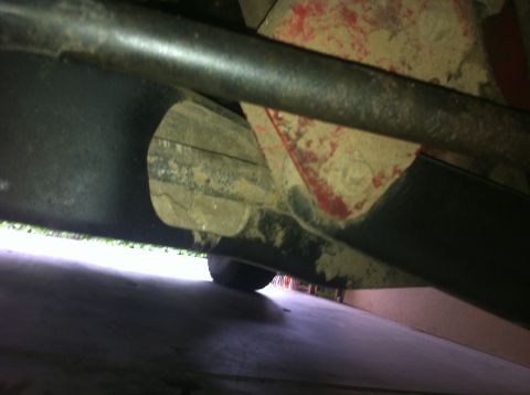 1990 Ford Bronco - This image shows the undercarriage of a vehicle, focusing on suspension components and some red paint.