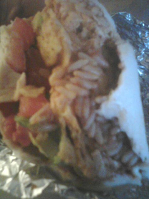 1988 Ford Bronco - A close-up view of a burrito, showing its fillings and foil wrapping.
