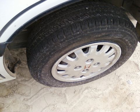 1991 Ford Festiva - This image shows a close-up of a car's wheel and tire, a distinct Honda emblem on the hubcap.