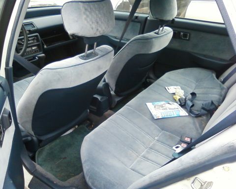 1991 Ford Festiva - Interior view of a car, showing the front and rear seats, dashboard, and door panel.