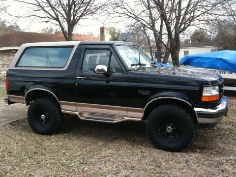 1996 Ford Bronco - A black 1996 Ford Bronco with tan accents is viewed from the front three-quarter angle.