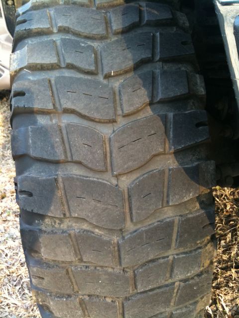 1996 Ford Bronco - A close-up view of a off-road tire, showing its aggressive tread pattern designed for traction.