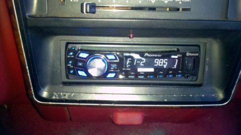 1989 Ford Bronco - The interior of a vehicle shows a Pioneer car stereo with a blue illuminated display tuned to 98.5 FM.