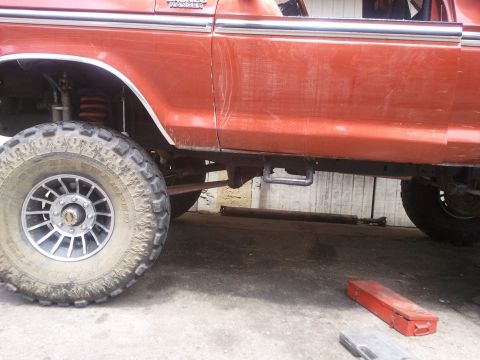 1978 Ford Bronco - Side view of an orange 1978 Ford Bronco with lifted suspension and off-road tires.