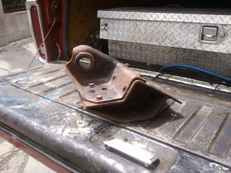 rusted metal suspension part sitting in truck bed