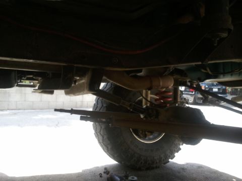 1978 Ford Bronco - The underside of a vehicle, with suspension and tire details visible, and another vehicle in the distance.