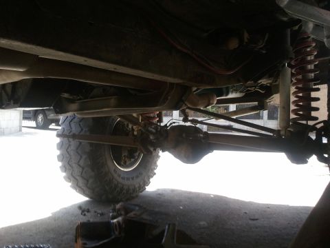 1978 Ford Bronco - A close-up view of the undercarriage reveals the suspension system and a large off-road tire.