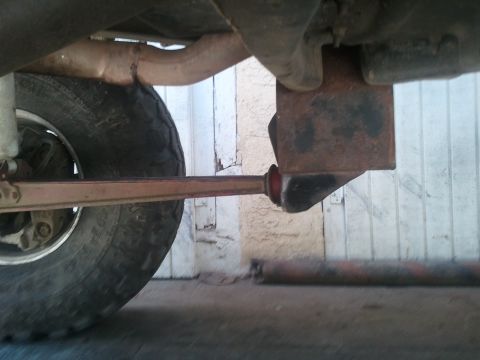 1978 Ford Bronco - Close-up view of a vehicle's undercarriage, focusing on suspension and exhaust systems.