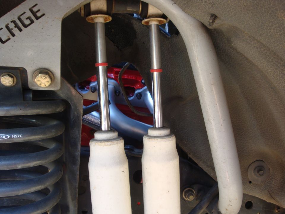 Close-up of white shock absorbers and red engine components